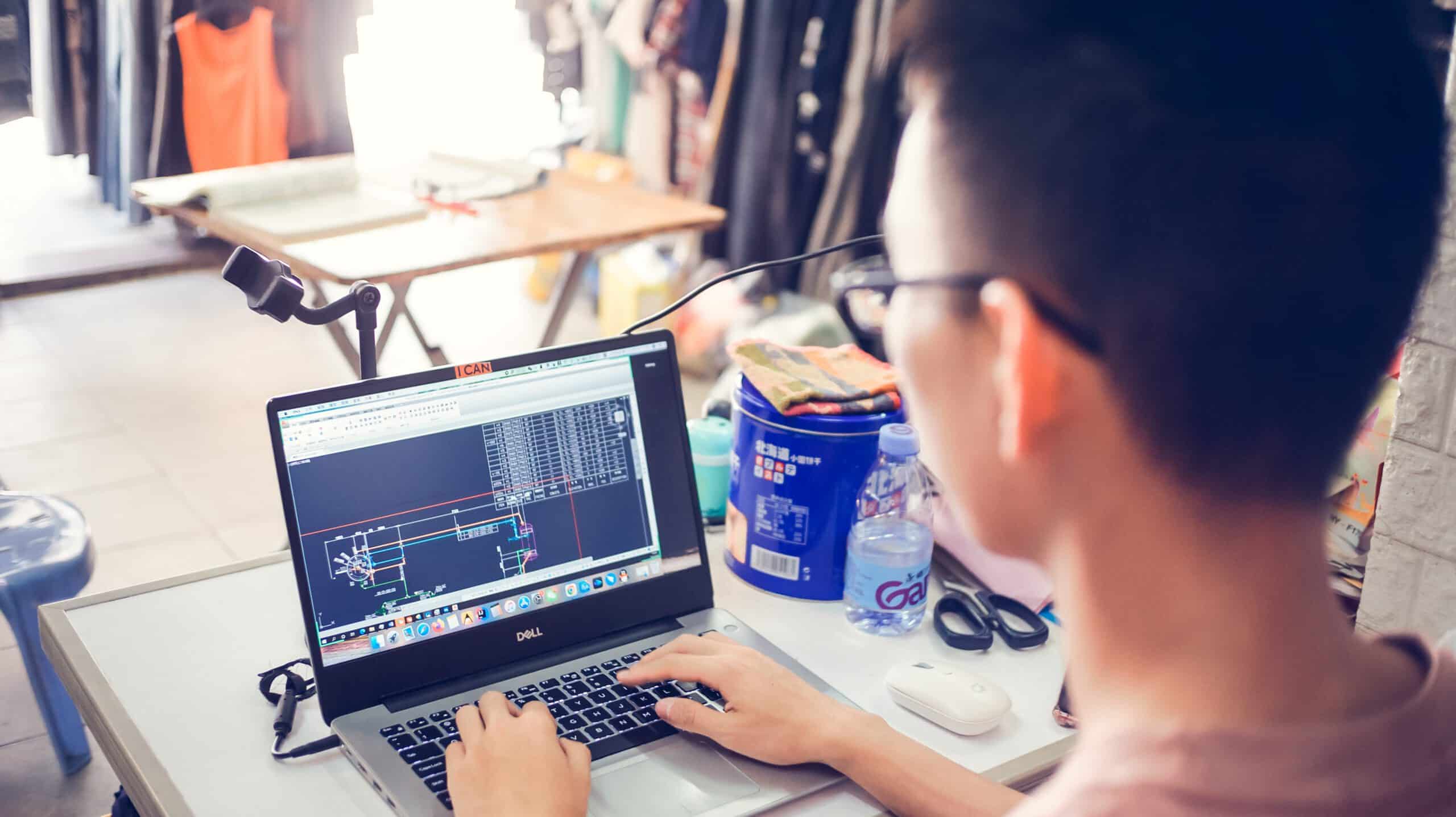 person in front of laptop using autocad