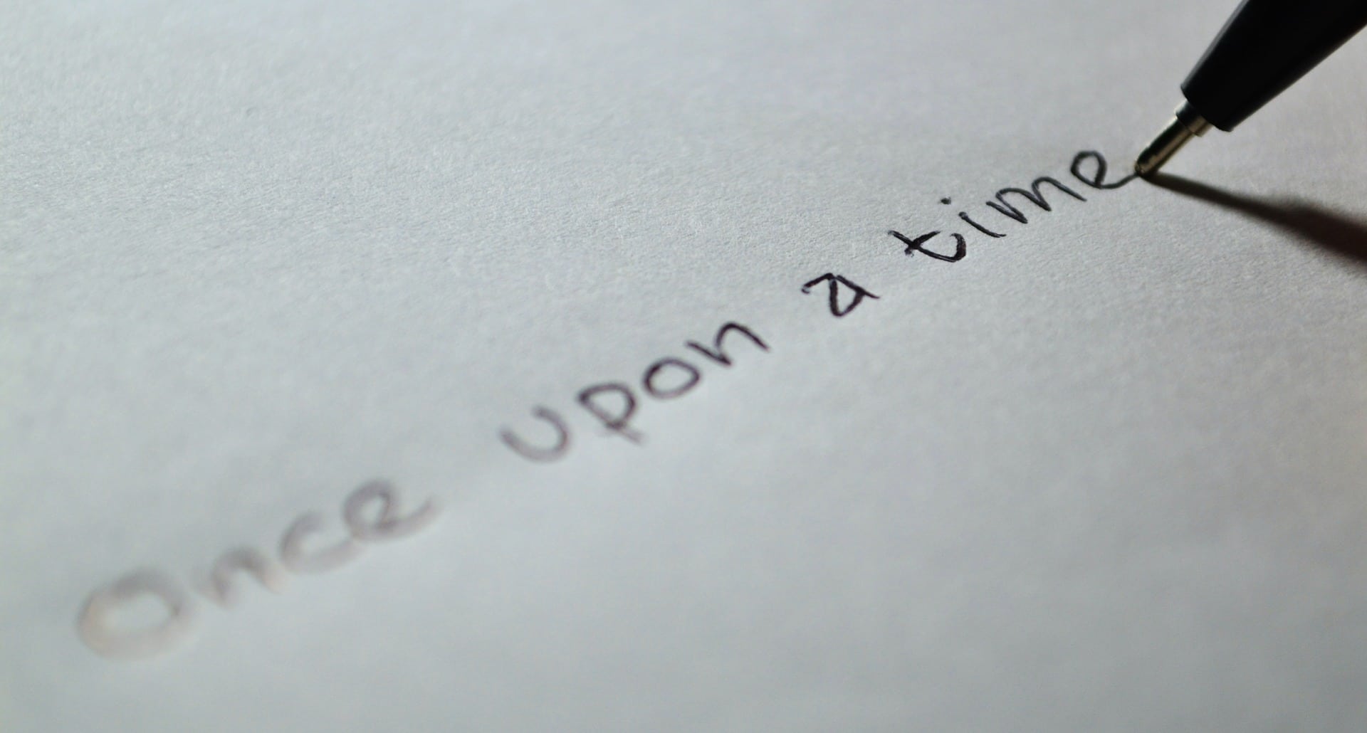pen on paper, writing "once upon a time"
