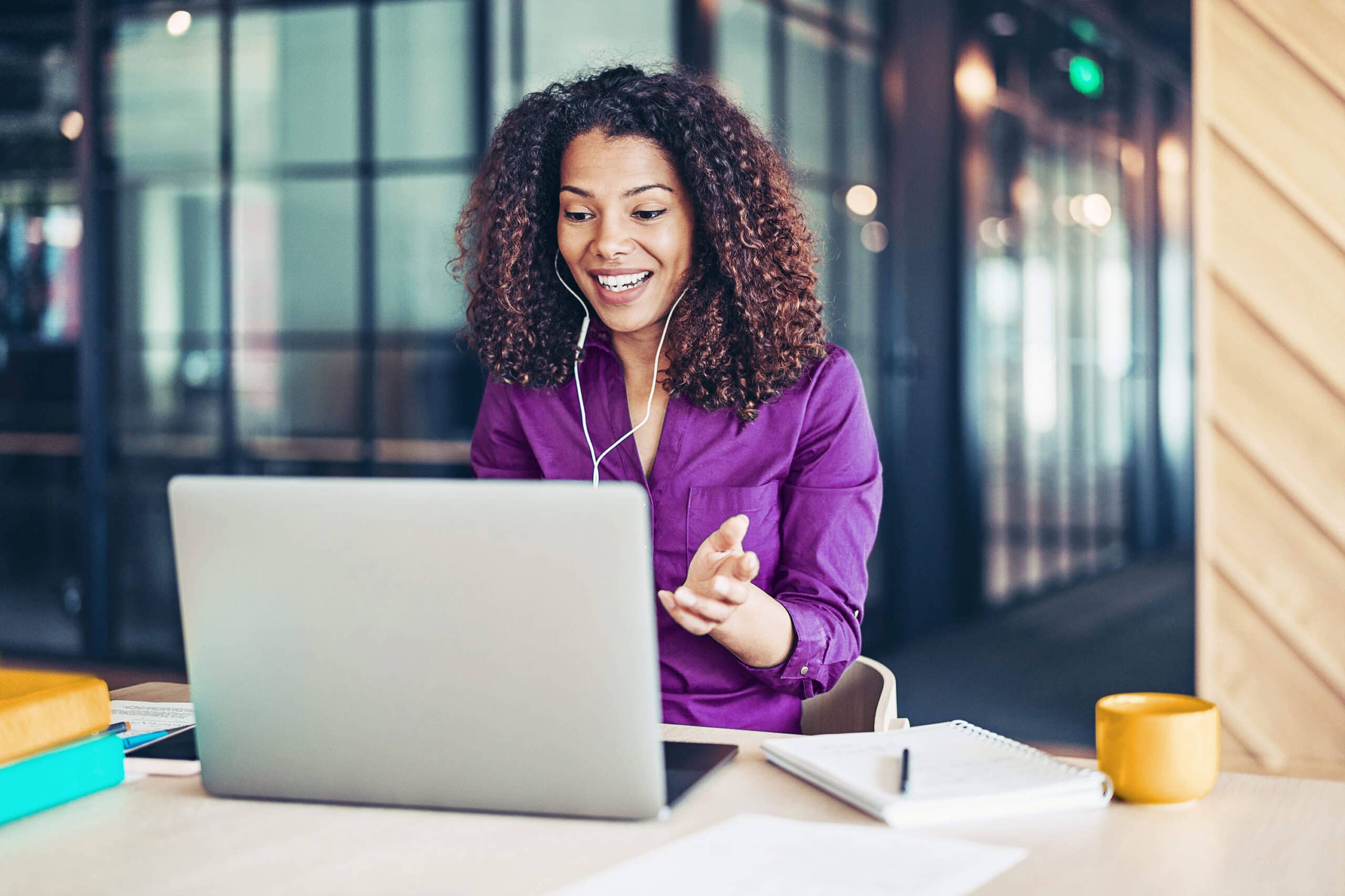 Person at desk in front of laptop with headphones 