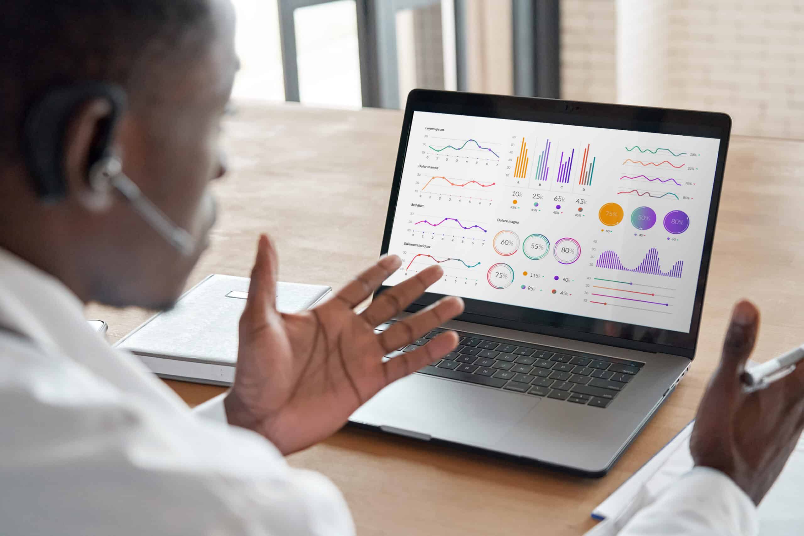 Person in front of laptop displaying dashboards